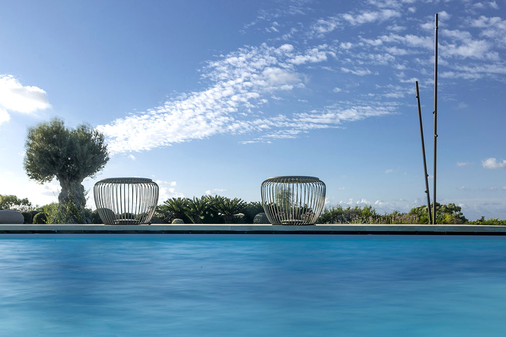 Dos piezas de Meridiano proyectan su sombra en la piscina de Villa Rihana que se funde con el azul de mar de la isla de Malta