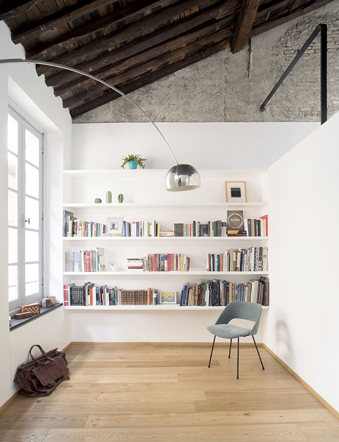 Vista de las bigas originales del techo y de la zona de lectura del apartamento en Génova rehabilitado por Dodi Moss, en primer ´termino lámpara Arco de Achille Castiglioni que edita Flos