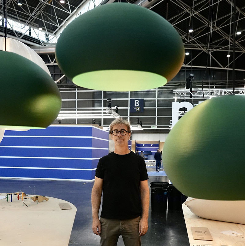 Héctor Serrano delante de las lámparas Mar de Faro Barcelona que forman parte de su exposición en Habitat Valencia 2025
